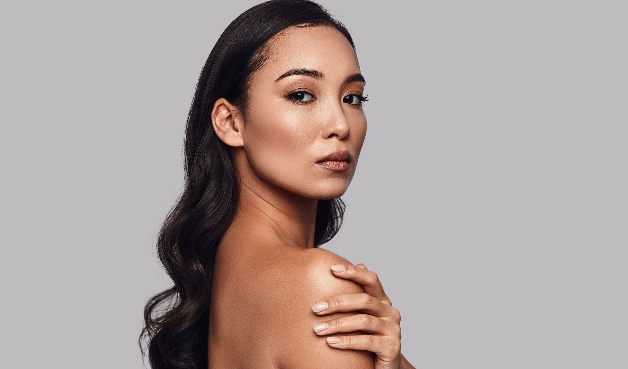 med spa paitnet model touching her shoulder